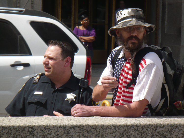Fascist protected by cops is escorted away from the Tea Partiers' rally after counter-demonstrators surrounded him and began chanting "Nazis go home!"